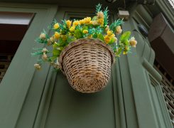 A,Basket,Of,Yellow,Artificial,Flowers,Hanging,At,The,Corner